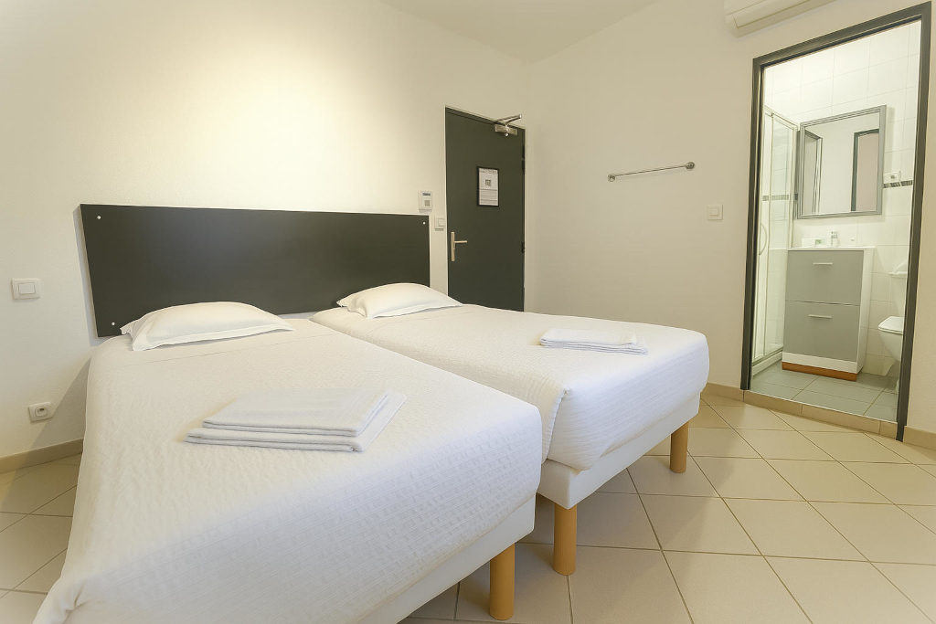 Chambre twin à La Croix Valmer avec deux lits simples et accès à la salle de bain à l’hôtel La Cigale