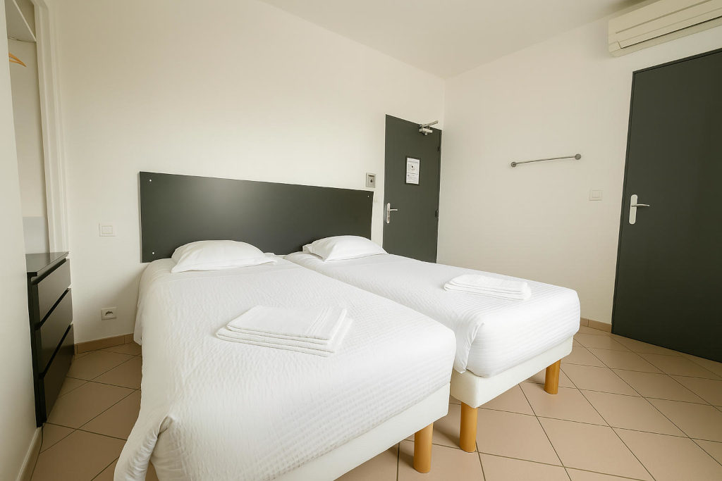 Chambre twin à La Croix Valmer avec deux lits simples et espace confortable à l’hôtel La Cigale