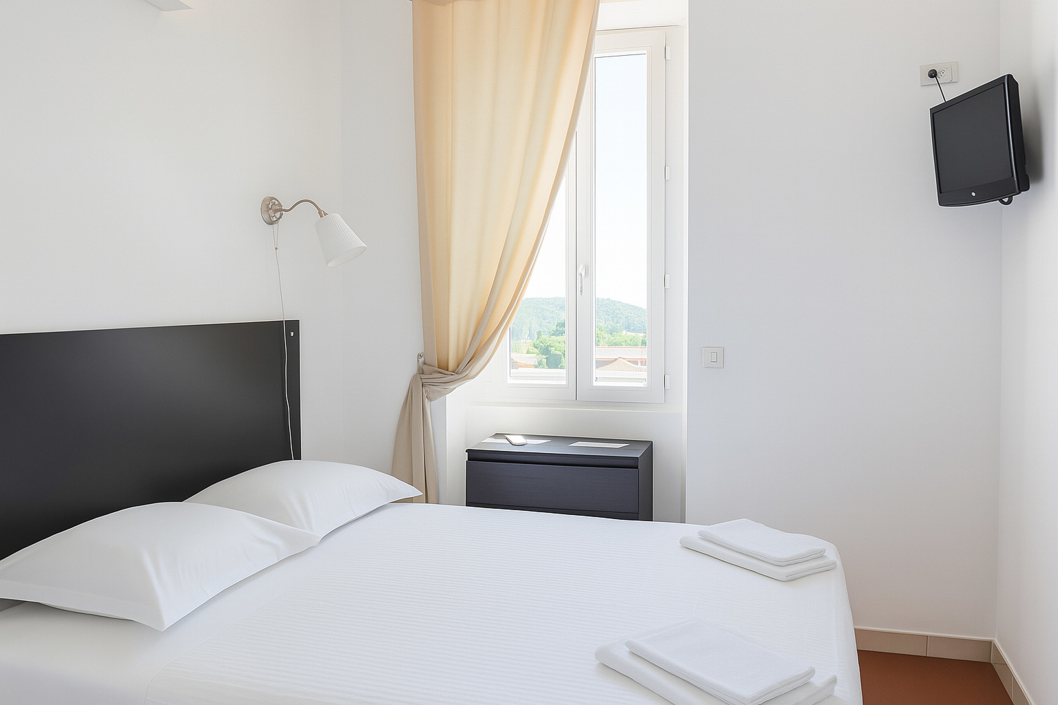 Chambre vue rue avec lit double et fenêtre lumineuse à l’hôtel La Cigale à La Croix Valmer